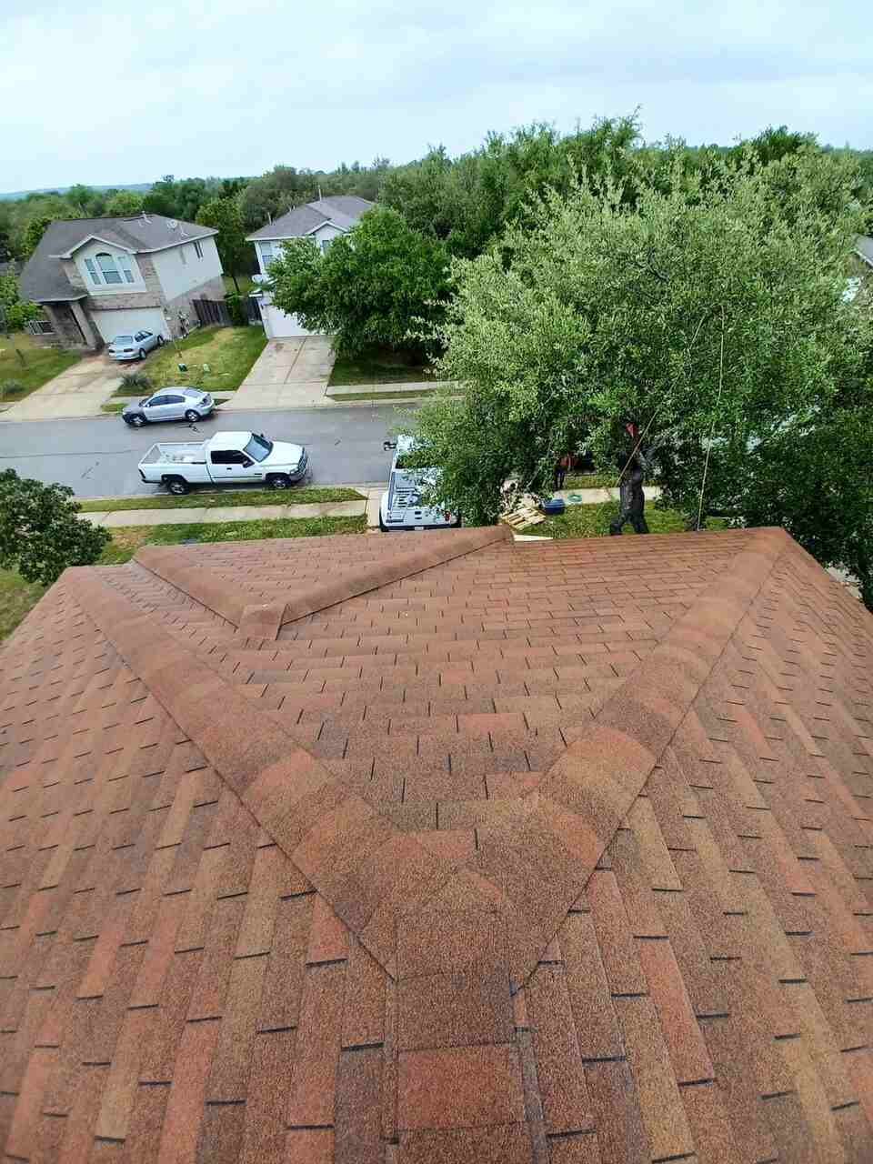 A house roof with trees and parked cars in Round Rock