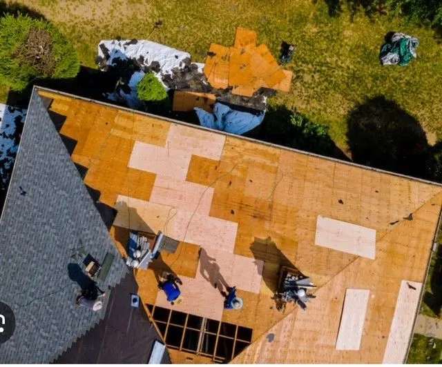 A rooftop with multiple professionals working on commercial roofing