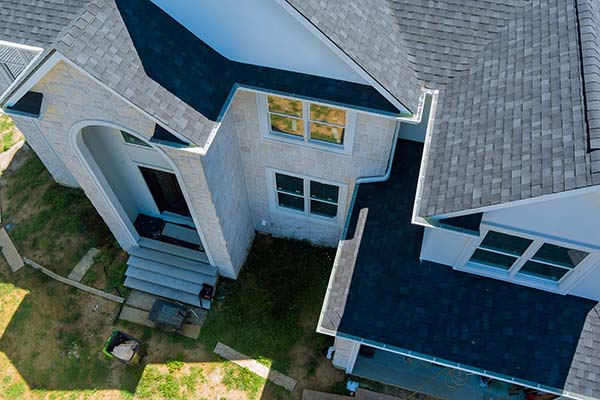 Top view of a house with lawn and worker outside in Leander