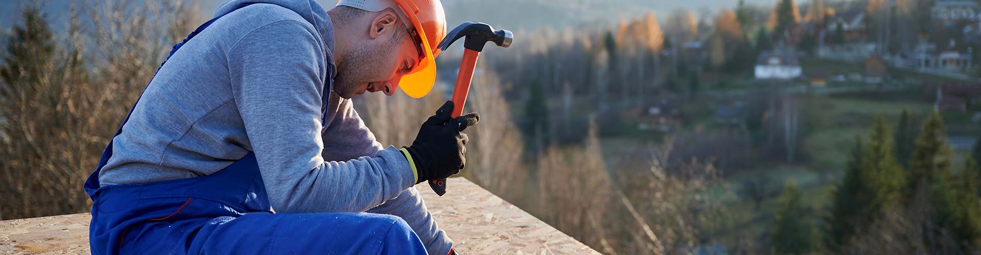 A person holding a hammer on a roof in Round Rock