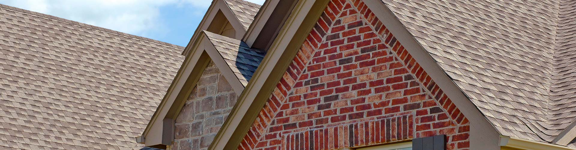 A close-up of a brick building with commercial roofing