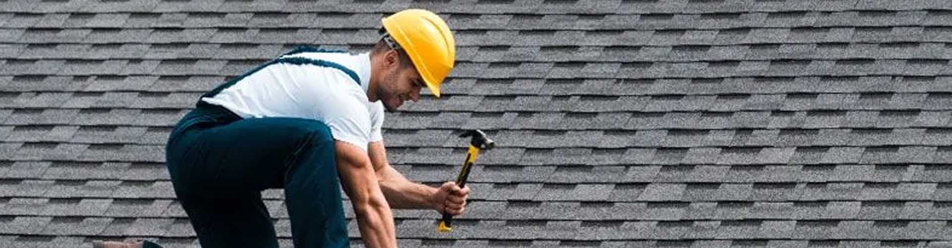 A person holding a hammer on a roof in Cedar Park